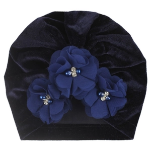 Détail du bonnet bébé en velours bleu foncé avec fleurs artisanales et perles fines