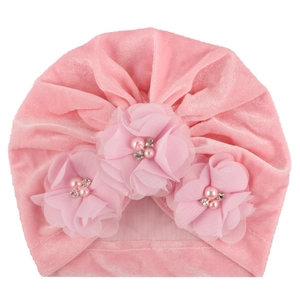 Détail du turban pour bébé en velours rose avec trois fleurs en mousseline et perles