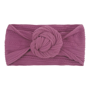 Dettaglio della fascia elastica in nylon viola con un grande nodo donut per neonati