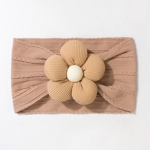 Detail of baby headband with ribbed coffee brown fabric and plush 3D floral accent