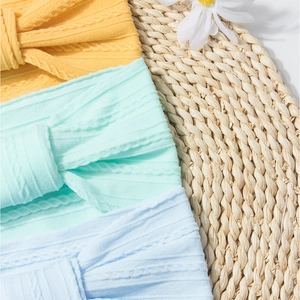 Detailed close-up of knitted cable pattern and bow design on baby nylon headbands