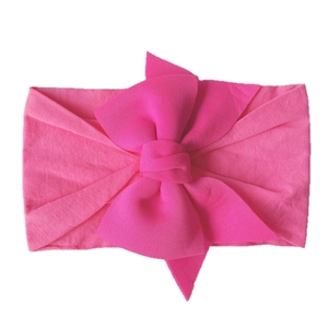 Pink soft nylon baby headband featuring a large bow on a clean white background