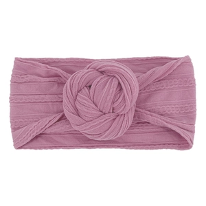 Dettaglio della fascia per neonati in nylon color malva con trama a trecce e nodo centrale