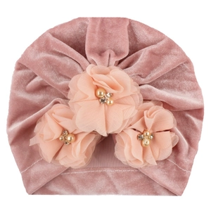 Détail du turban rose en velours pour bébé avec fleurs en tissu, perles et strass