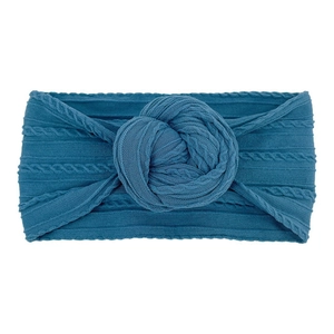 Vista dettagliata della fascia per neonati blu pavone con design a nodo in maglia morbida
