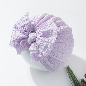 Detail of light purple baby knot hat featuring seersucker texture and a large bow