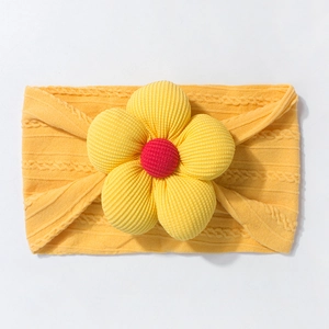 Detailed knit texture of baby yellow headband with a 3D flower and red center