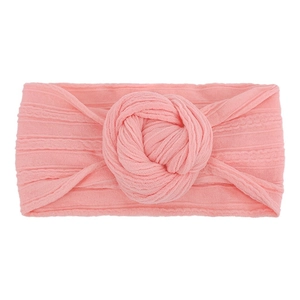 Dettaglio di una fascia per neonati rosa in nylon morbido con un grande fiocco a nodo