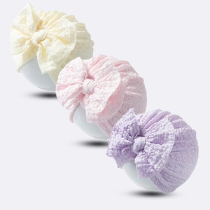 Three-piece set of soft elastic baby hats with large bows in cream, pink, and light purple