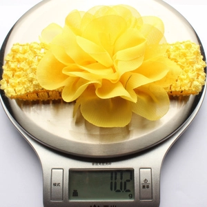Vue détaillée du bandeau fleur en mousseline jaune léger de 10,2g sur une balance