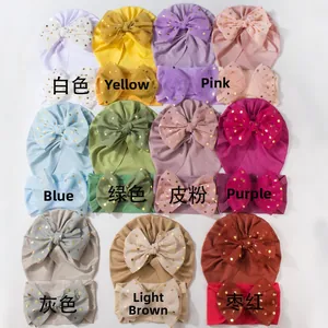 Detail view of colorful baby nylon headbands with gold polka dot mesh bows