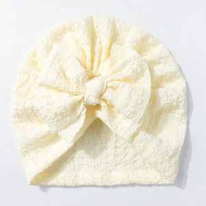Close-up of baby turban hat showing textured bubble gauze fabric and large bow detail