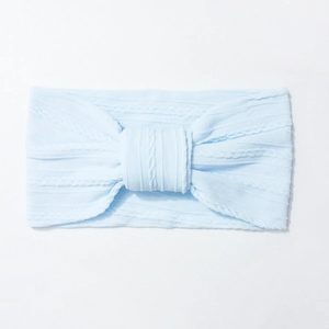 Detail of baby headband featuring light blue cable knit pattern and large center knot