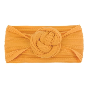 Dettaglio della fascia per neonati giallo senape in nylon a coste con nodo centrale