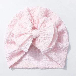 Pink infant turban hat featuring a large soft bow made of breathable waffle fabric