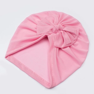 Close-up of pink baby turban hat showing soft mesh fabric and large bow detail