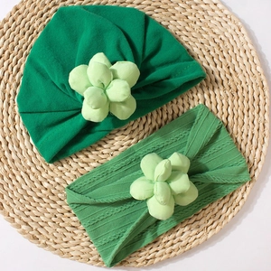 Detail view of baby turban and headband set featuring 3D sewn flower ornaments