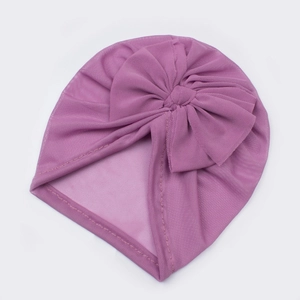 Detail view of breathable mesh texture and large bow on the infant turban hat