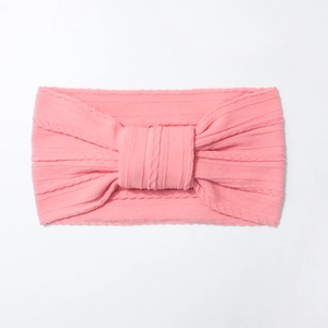 Detailed view of pink ribbed elastic nylon headband with a cute knotted bow for babies