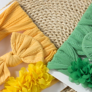 Détail de bandeaux pour bébé jaunes et verts avec nœuds et fleurs en tissu tricoté