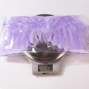Détail des ailes en plumes violettes pour bébés sur une balance pesant 17,8 grammes
