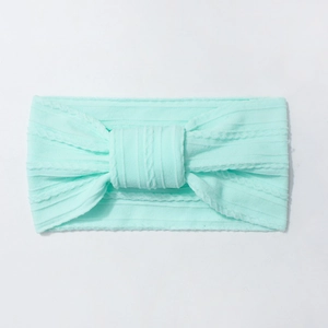 Detailed knit texture and knot bow design on a stretchy mint green baby nylon headband