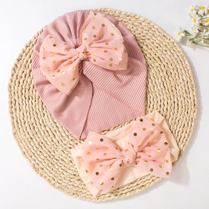 Detail of pink baby beanie and nylon headband set with gold polka dot mesh bows
