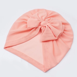 Detailed texture of peach pink mesh baby turban hat with a large decorative bow