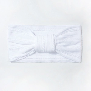 Macro detail of white cable knit nylon baby headband with soft texture and bow