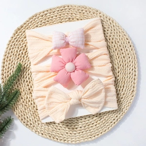 Détails de trois bandeaux pour bébé avec nœuds roses et fleurs sur une carte de support