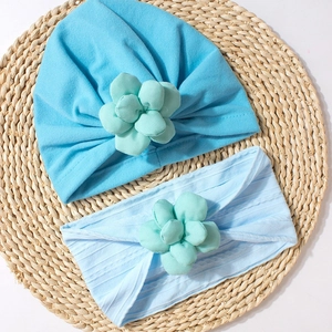 Detail of sky blue cotton baby turban hat and headband with mint green fabric flowers