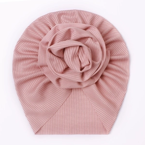 Detailed view of the dusty pink ribbed baby turban hat with a large floral decoration