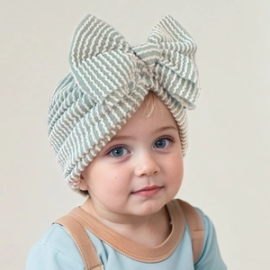 Detailed view of the soft ribbed texture and large bow on striped newborn turban hat