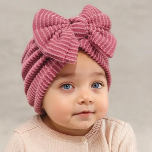 Detail of baby striped knit beanie with large 3D bow in berry pink fabric texture