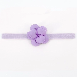 Dettaglio del fiore in tessuto viola su fascia elastica per neonati e bambine
