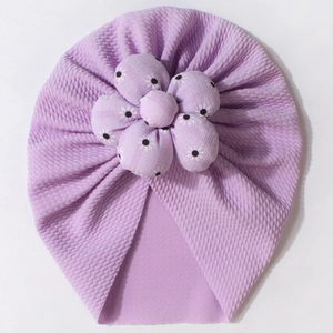 Detail view of lavender waffle knit baby turban hat with large 3D floral decoration
