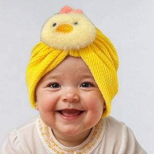 Detailed view of yellow waffle knit baby beanie featuring a cute plush chicken doll on top