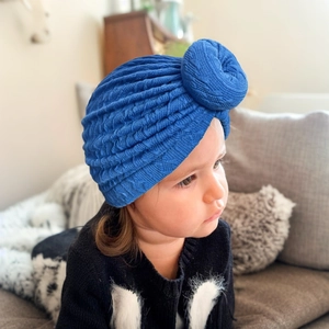 Detailed knit texture of royal blue baby donut turban hat with a large knot decoration