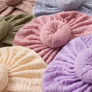 Detail of soft knit baby hats featuring jacquard texture and cute donut-shaped top knots