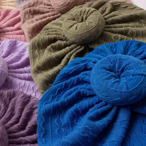 Detailed close-up of soft knit doughnut turbans showing colorful textured cable patterns