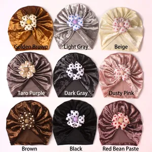 Detail display of baby velvet turban hats in nine colors with polka dot flower accents