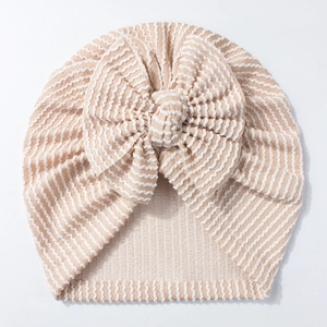 Detailed view of striped newborn hat featuring a large soft waffle knit bow detail