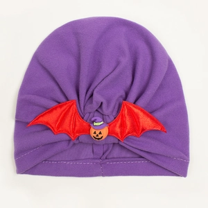 Detail of baby Halloween turban hat in purple fabric with bat wings and pumpkin
