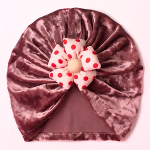 Detailed close-up of velvet baby hat featuring a 3D red polka dot floral decoration