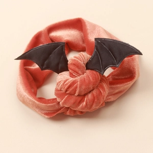 Close-up of pink velvet Halloween baby headband with a black bat wing center decoration