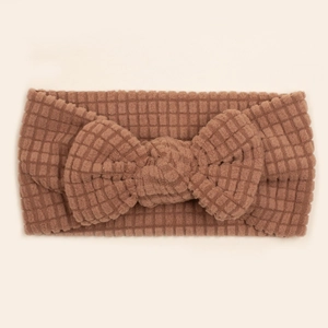 Brown waffle knit baby headband featuring a large bow on a soft elastic hair band