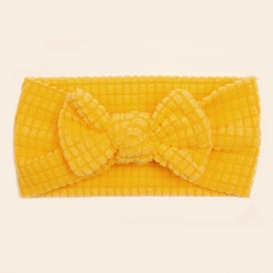Close-up of yellow waffle fabric baby headband with a large bow detail and soft texture