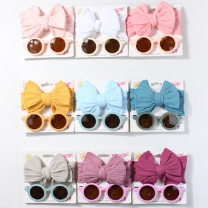 Nine pairs of baby waffle headbands and matching round sunglasses in multiple bright colors