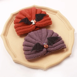 Detailed knit texture of baby Halloween turban hats with pumpkin and bat wing elements