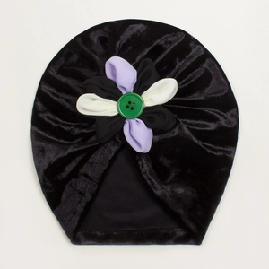 Détail du bonnet en velours pour bébé avec fleur tricolore noire violette et blanche
